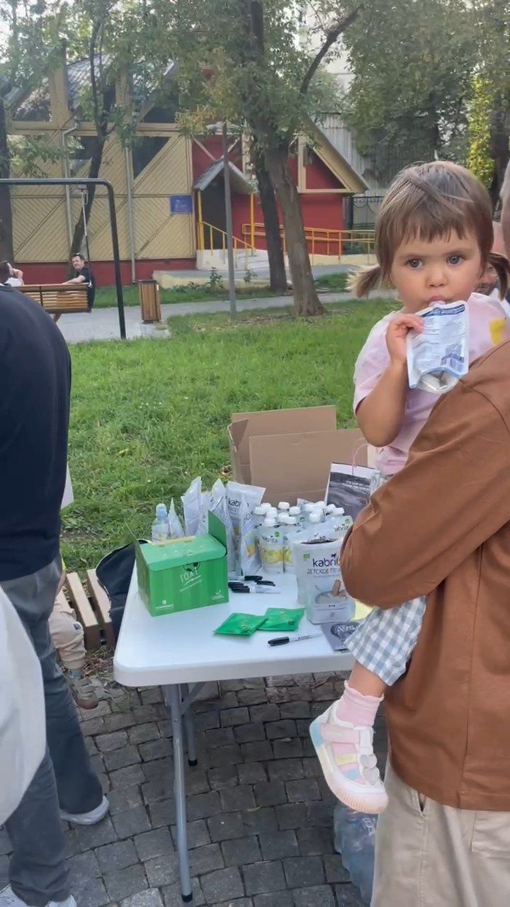 Ребёнок на руках у взрослого рядом со столом партнёров